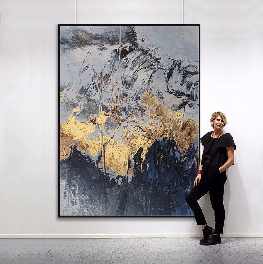 a woman standing in front of a large painting