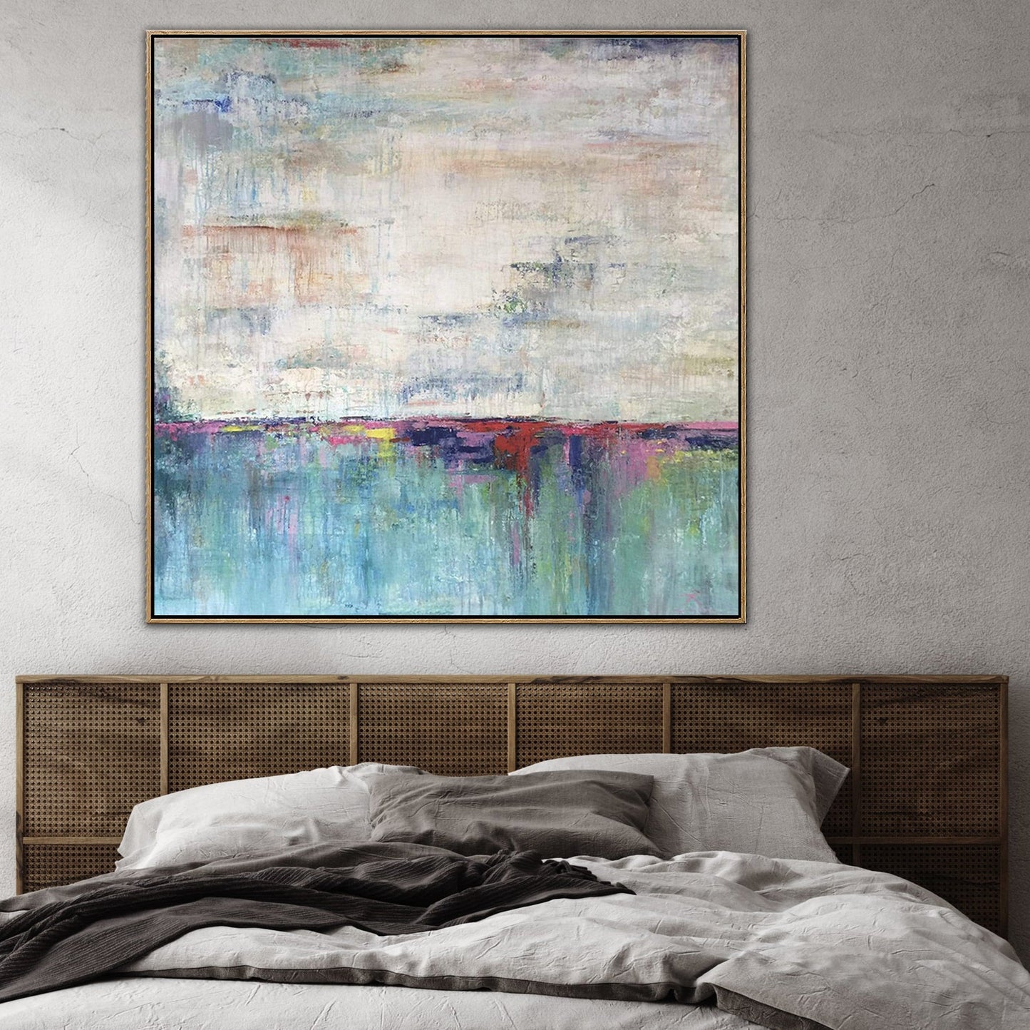 a large abstract painting hanging on a wall above a bed with a wooden headboard.