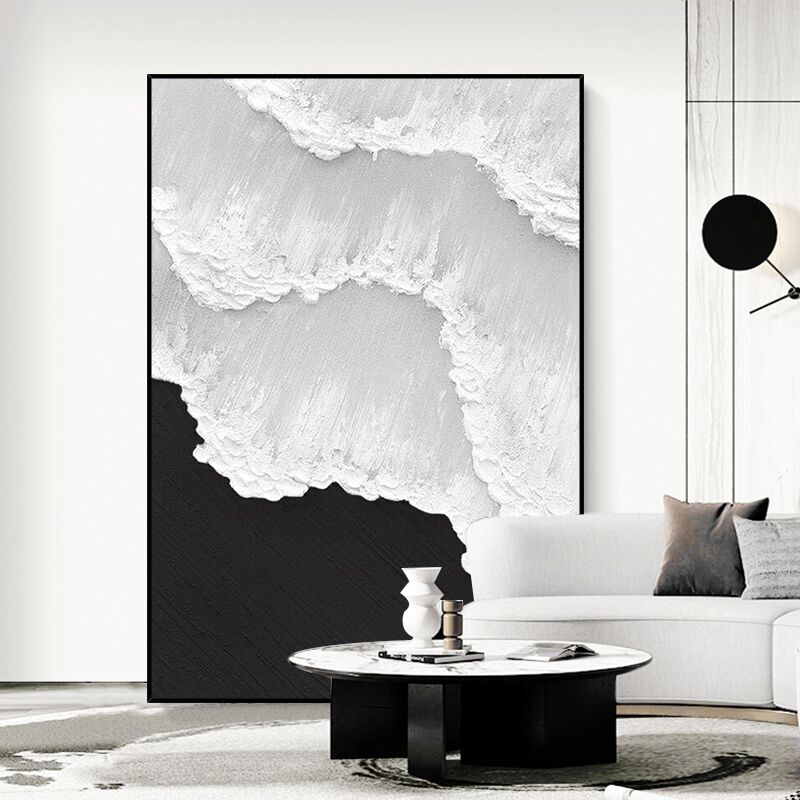 a living room with a white couch and a black and white painting