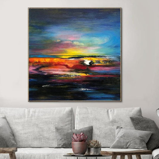 a vibrant abstract painting hanging on a wall above a gray couch with a coffee table in front of it.