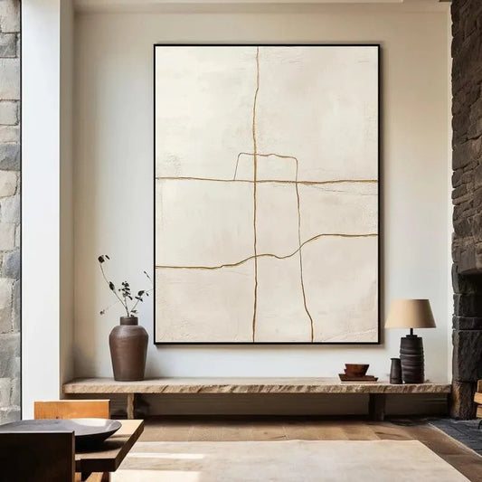 a minimalist living room with a large abstract painting hanging on the wall above a wooden shelf. The painting has a white background with bold lines and shapes, creating a striking visual contrast. The room also includes a fireplace, a wooden table, and a vase with flowers, adding a touch of warmth and natural elements to the space.