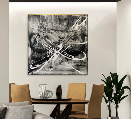 a black and white painting hangs above a dining room table