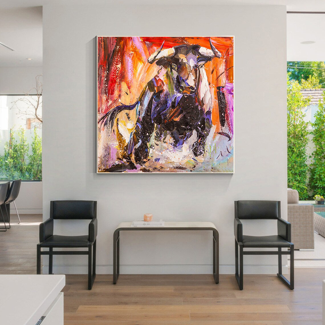 a living room with two chairs and a painting on the wall