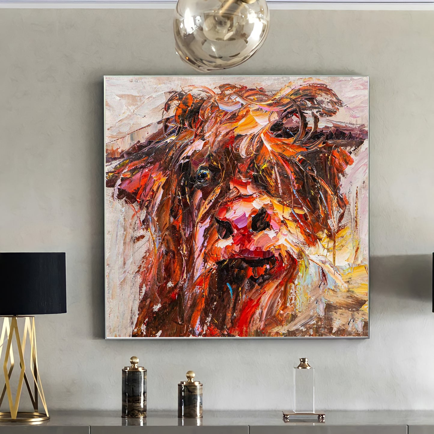 a painting of a cow is hanging on a wall