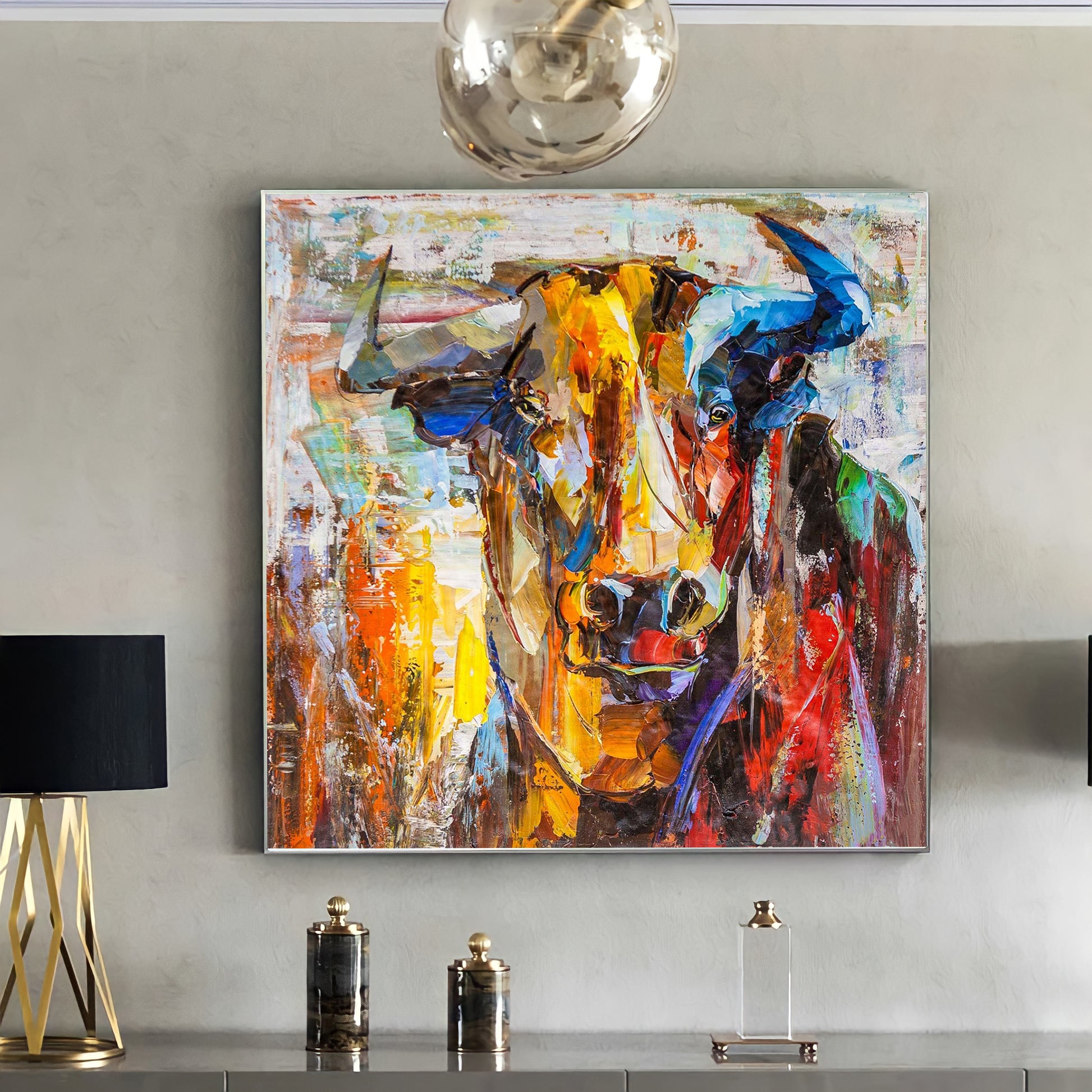 a painting of a cow is hanging on a wall