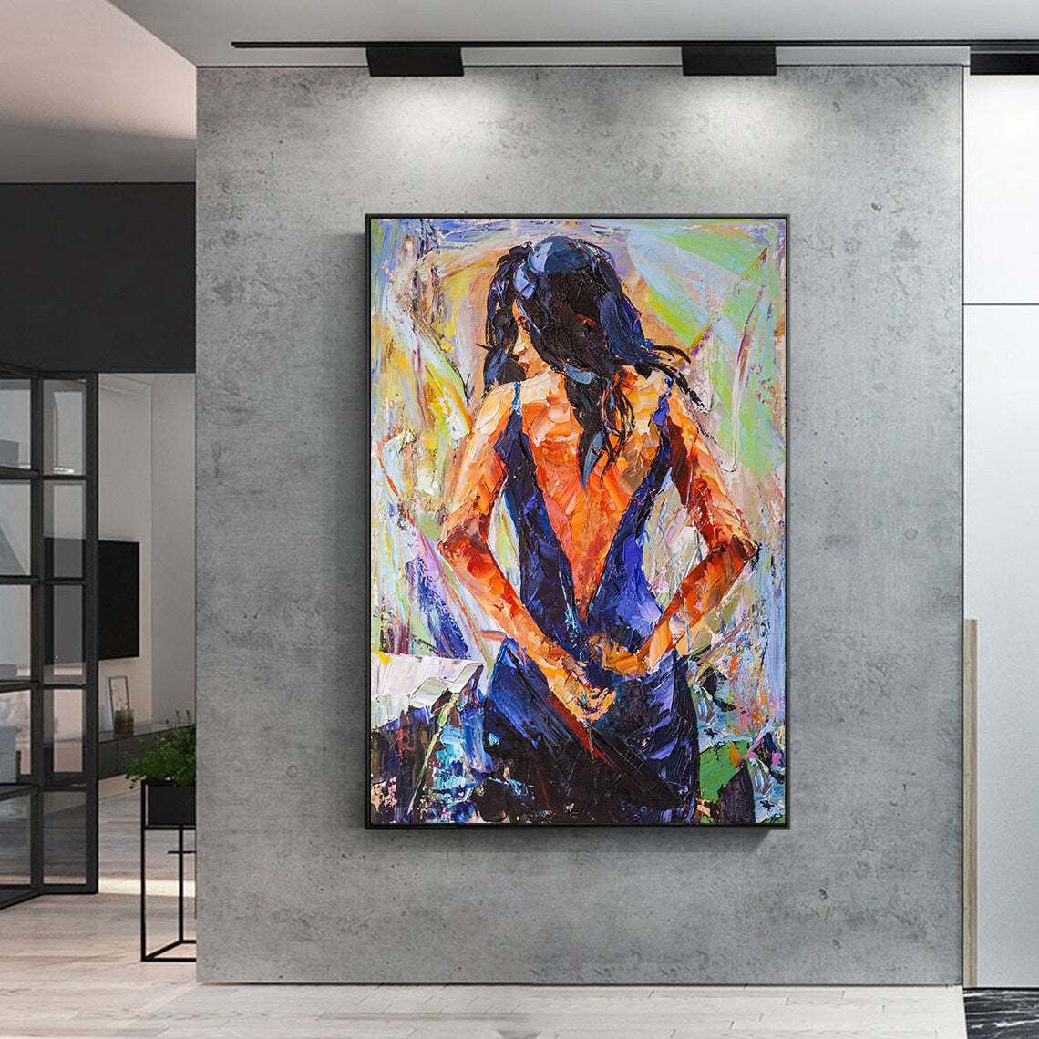 a painting of a woman is hanging on a wall