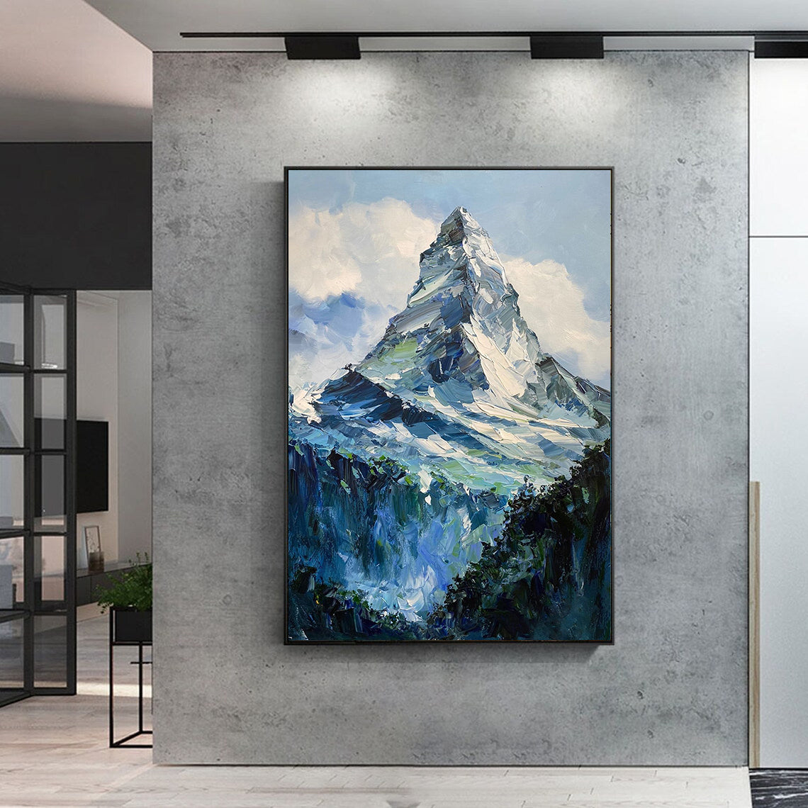 a painting of a mountain is hanging on a wall